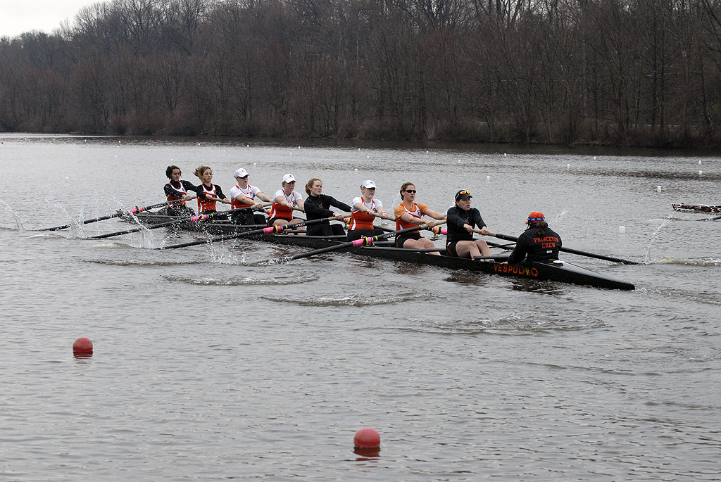 A group of people rowing a boat in the water