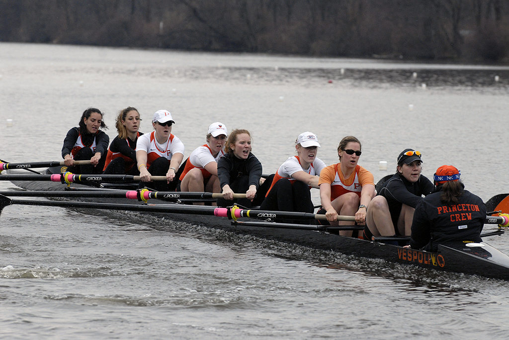 A group of people rowing a boat in the water