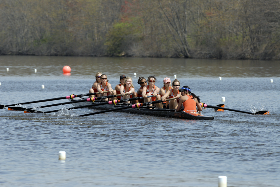 A group of people rowing a boat in a body of water