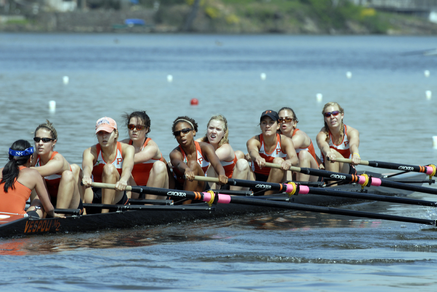 A group of people rowing a boat in a body of water