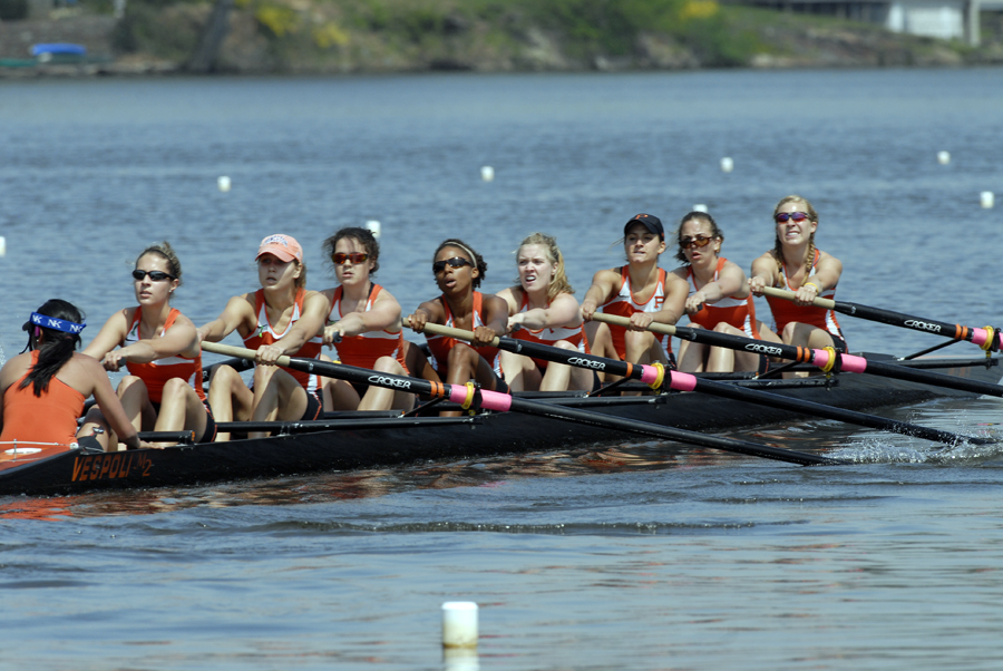 A group of people rowing a boat in a body of water