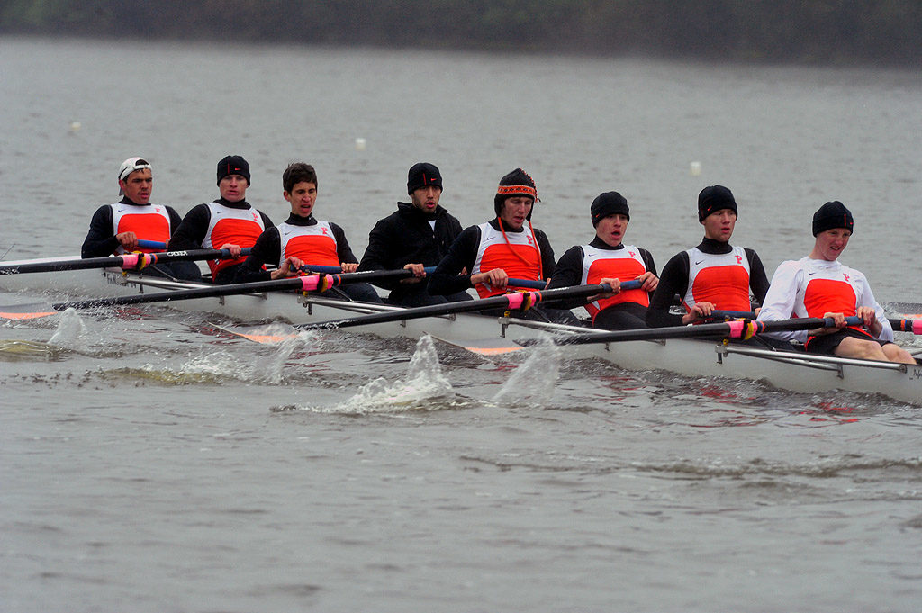 A group of people rowing a boat in the water