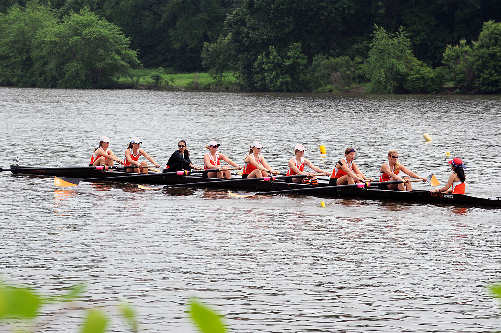 A group of people rowing a boat in a body of water