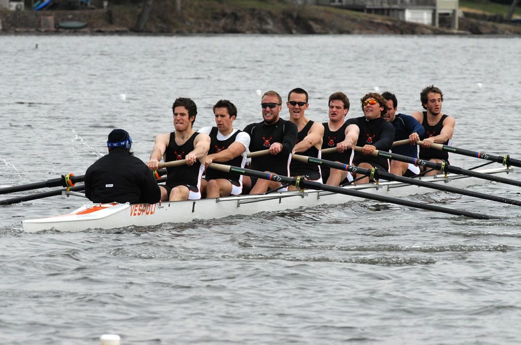 A group of people rowing a boat in the water