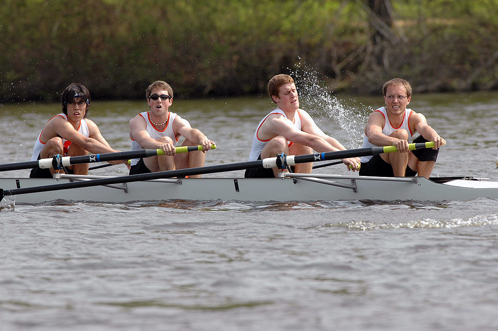 A group of people rowing a boat in the water