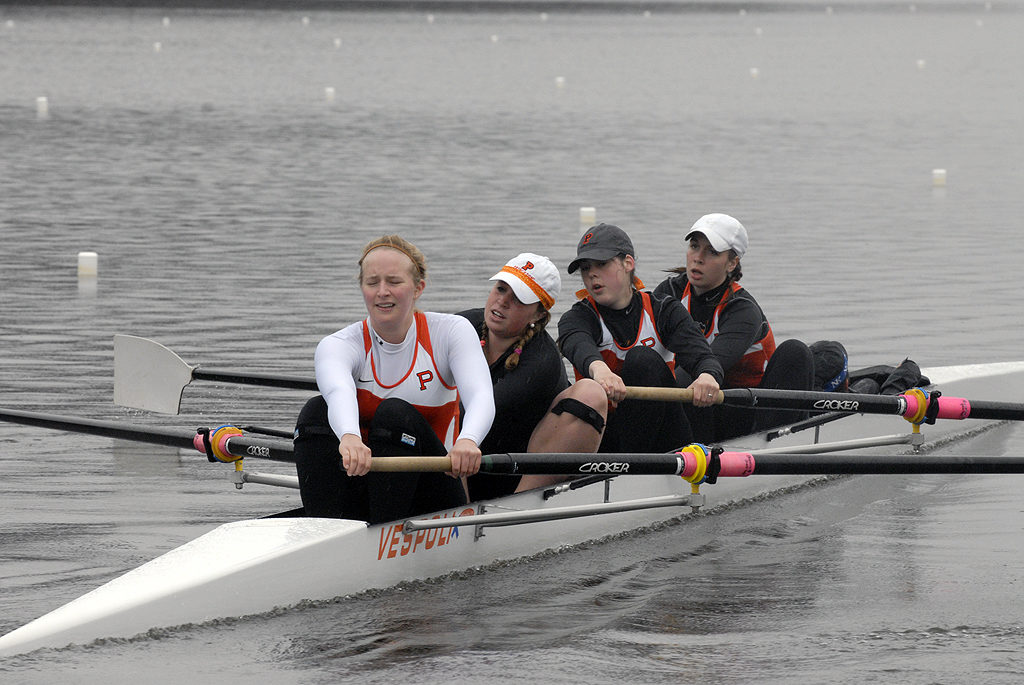 A group of people rowing a boat in the water