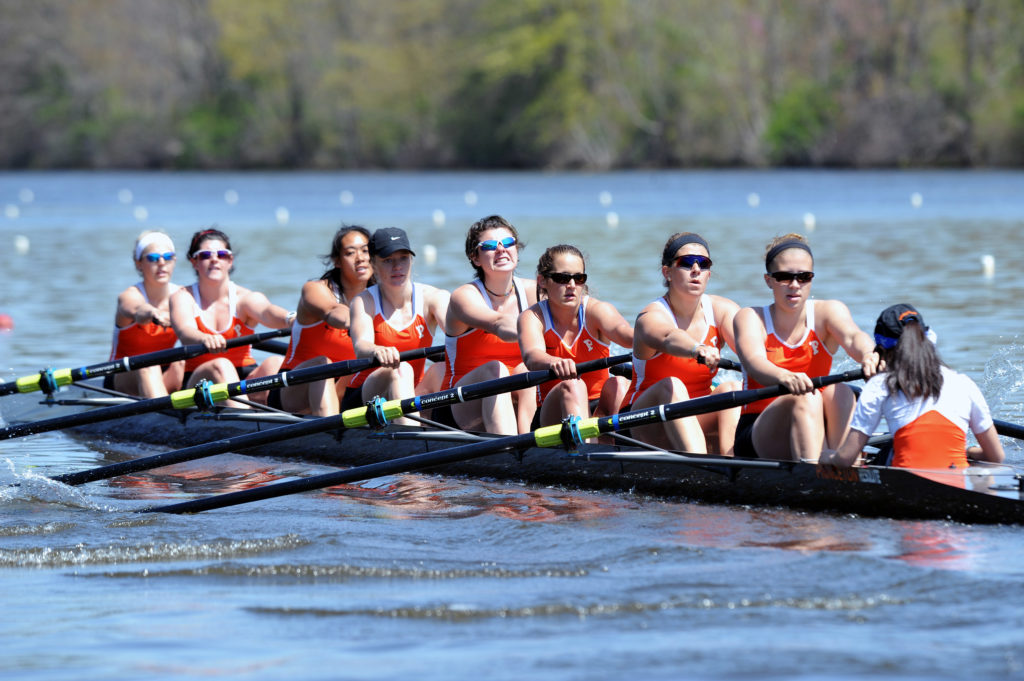 A group of people rowing a boat in a body of water