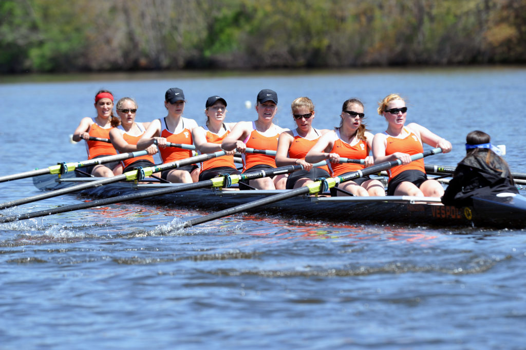 A group of people rowing a boat in a body of water