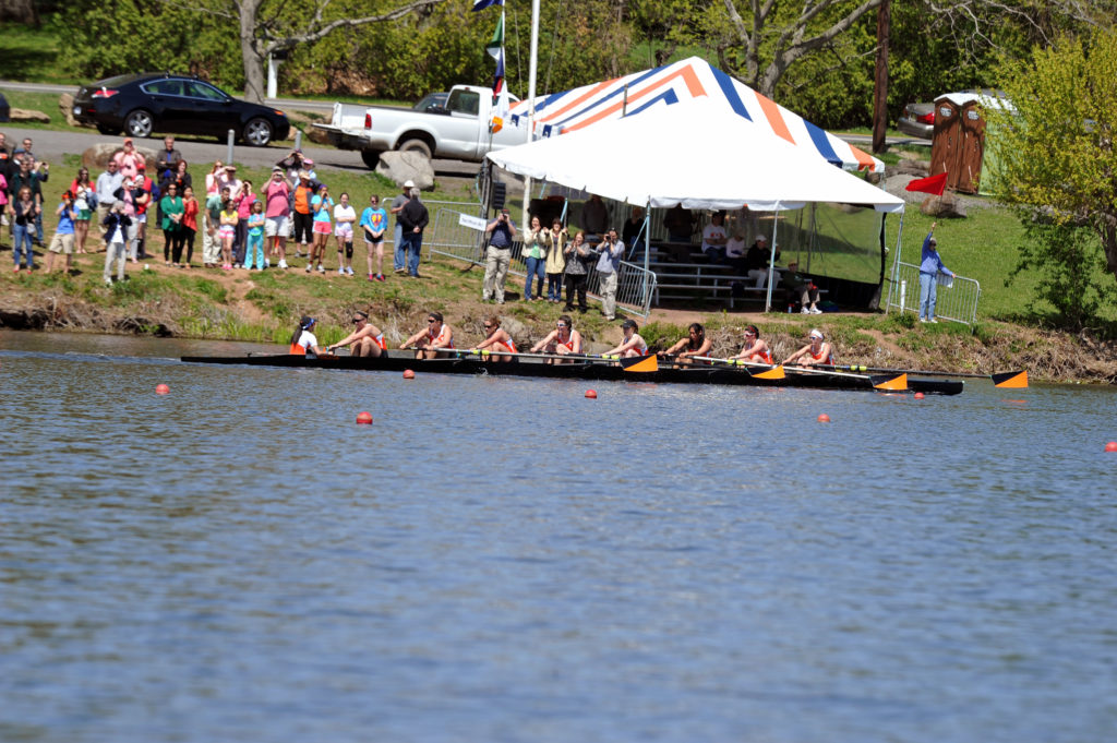 A group of people rowing a boat in a body of water