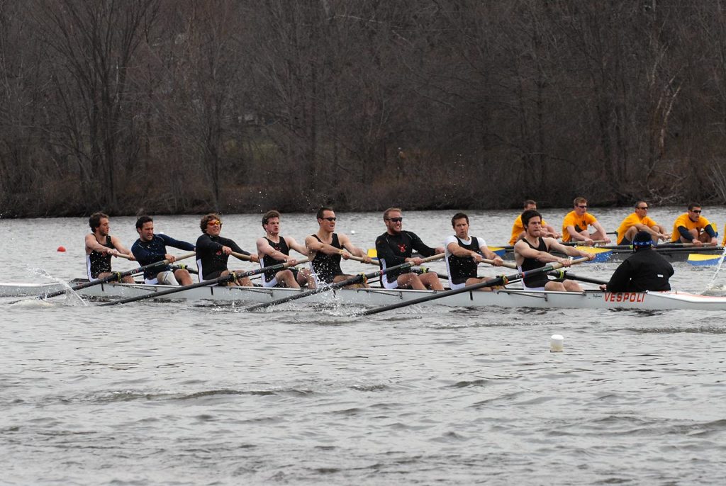 A group of people rowing a boat in the water