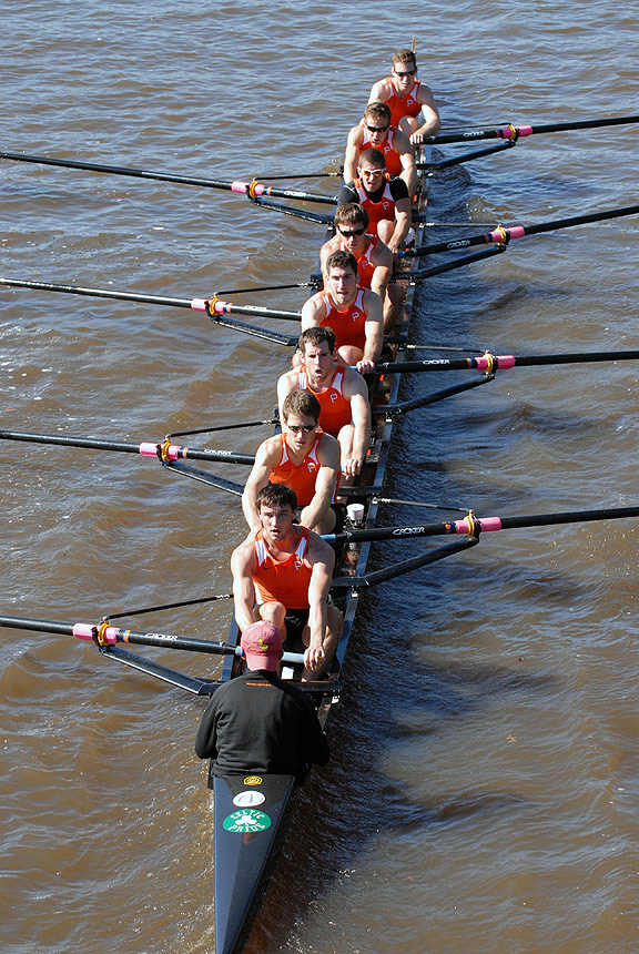 A group of people rowing a boat in the water