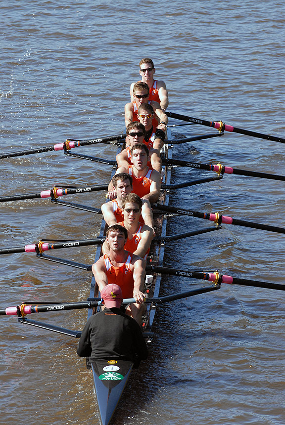 A group of people rowing a boat in a body of water