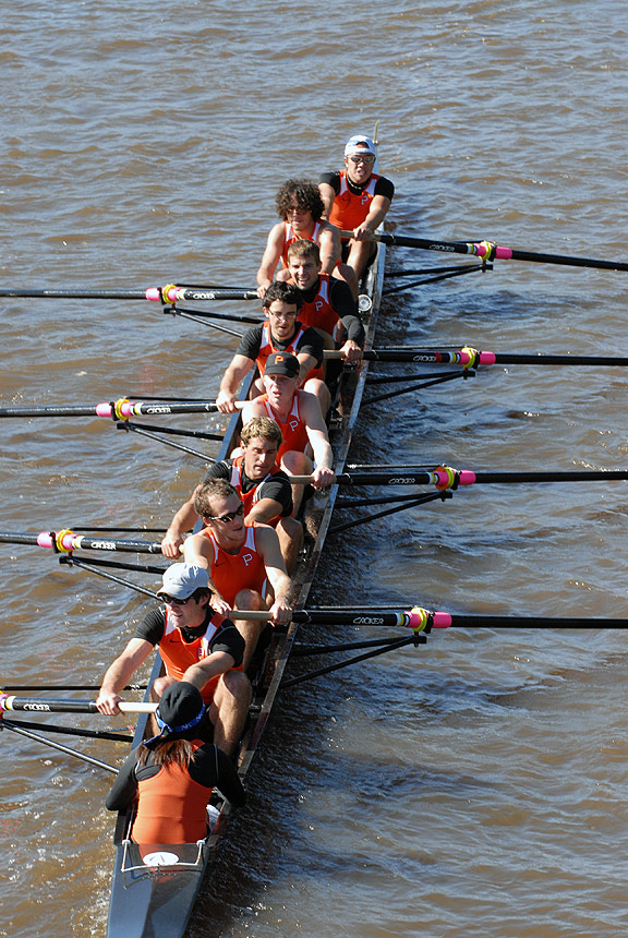 A group of people rowing a boat in the water