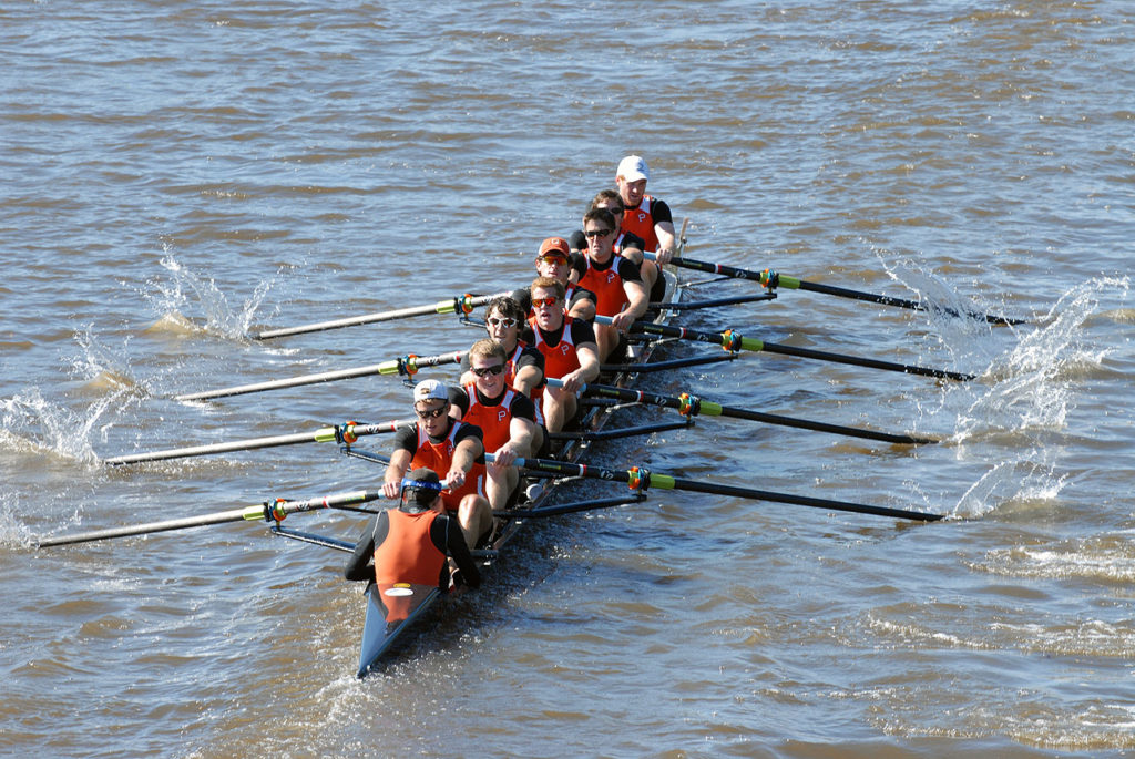 A group of people rowing a boat in the water