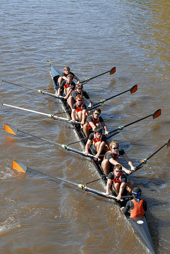 A group of people rowing a boat in a body of water