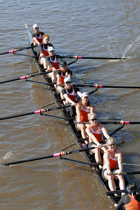 A group of people rowing a boat in a body of water