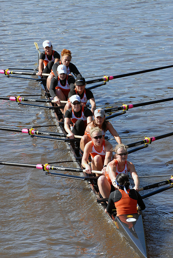 A group of people rowing a boat in a body of water