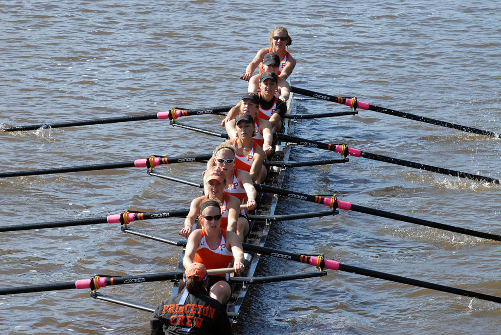 A group of people rowing a boat in a body of water