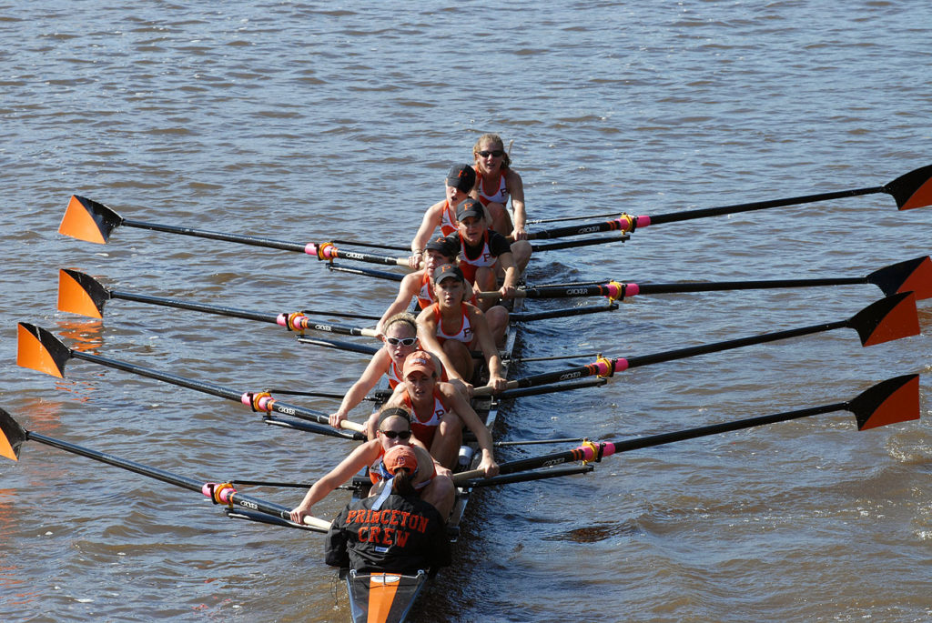 A group of people rowing a boat in the water