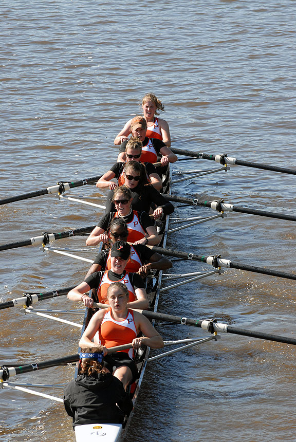 A group of people rowing a boat in a body of water