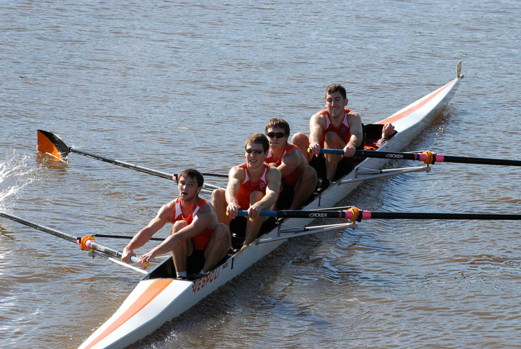 A group of people rowing a boat in the water