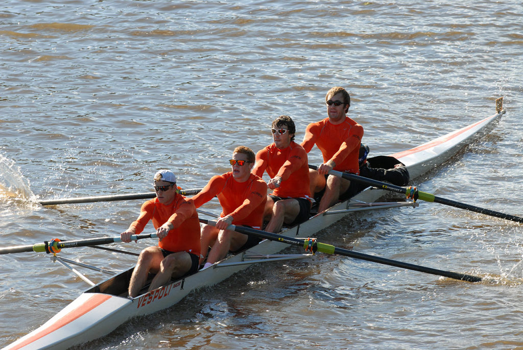 A group of people rowing a boat in the water