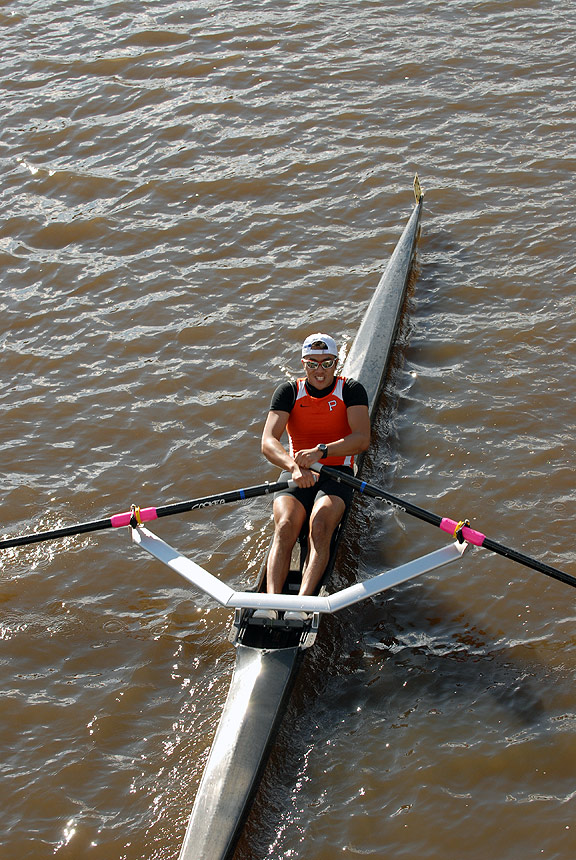 A person rowing a boat in a body of water