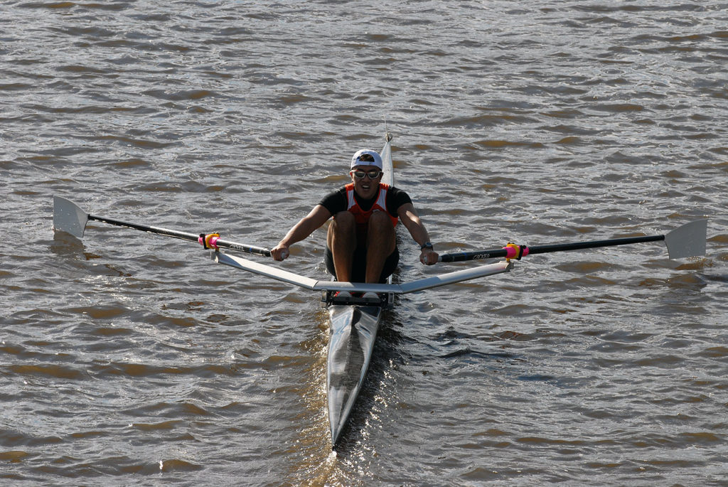 A man rowing a boat in a body of water