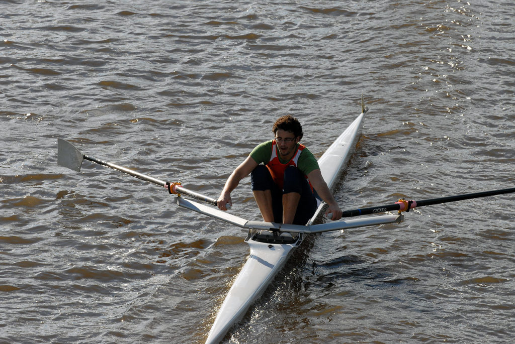 A man rowing a boat in a body of water