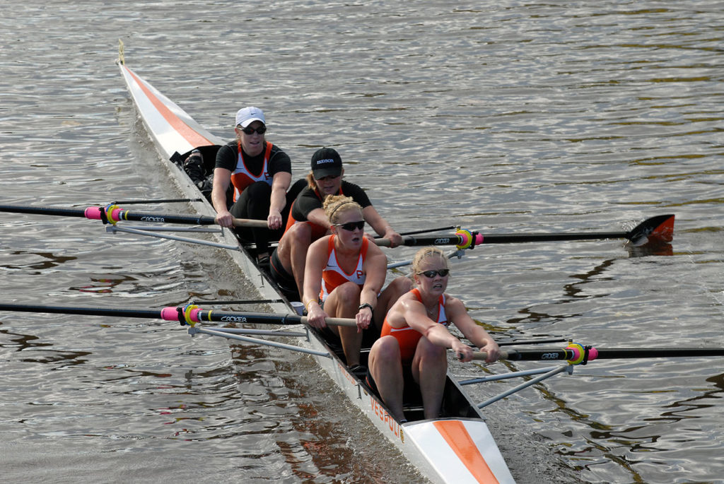 A group of people rowing a boat in the water