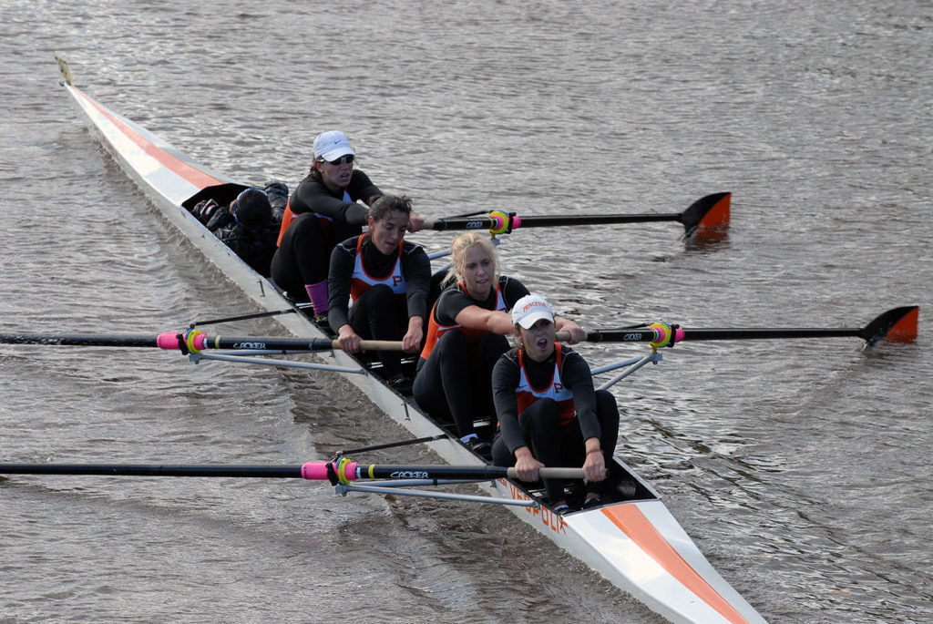 A group of people rowing a boat in the water