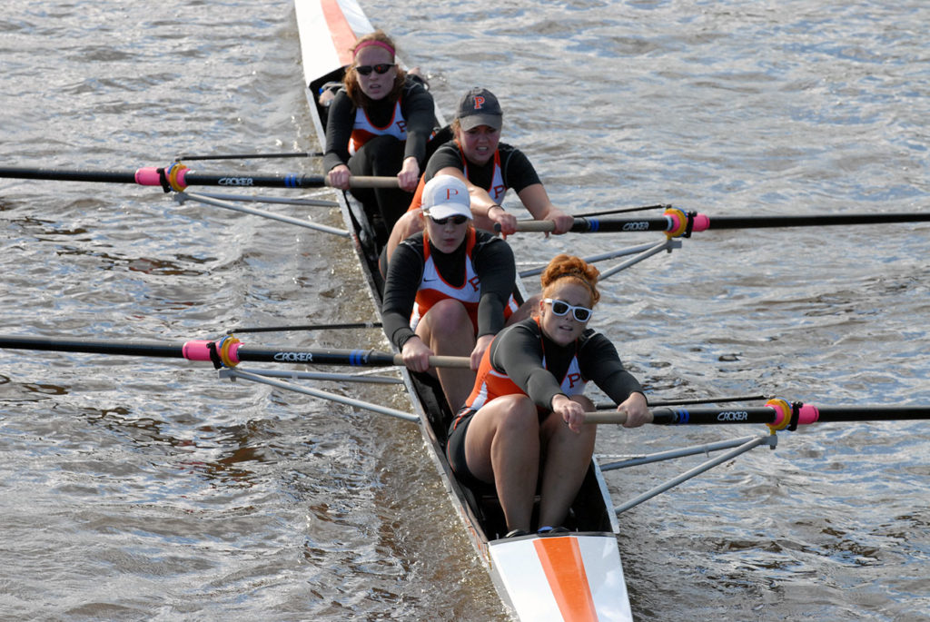 A group of people rowing a boat in the water