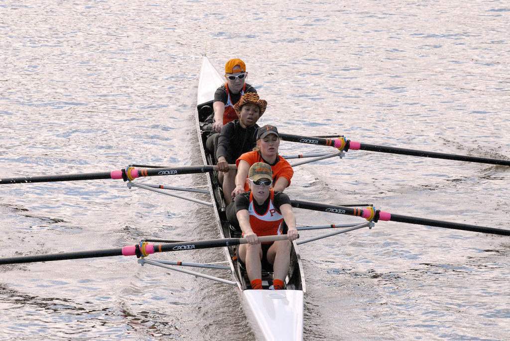 A group of people rowing a boat in the water