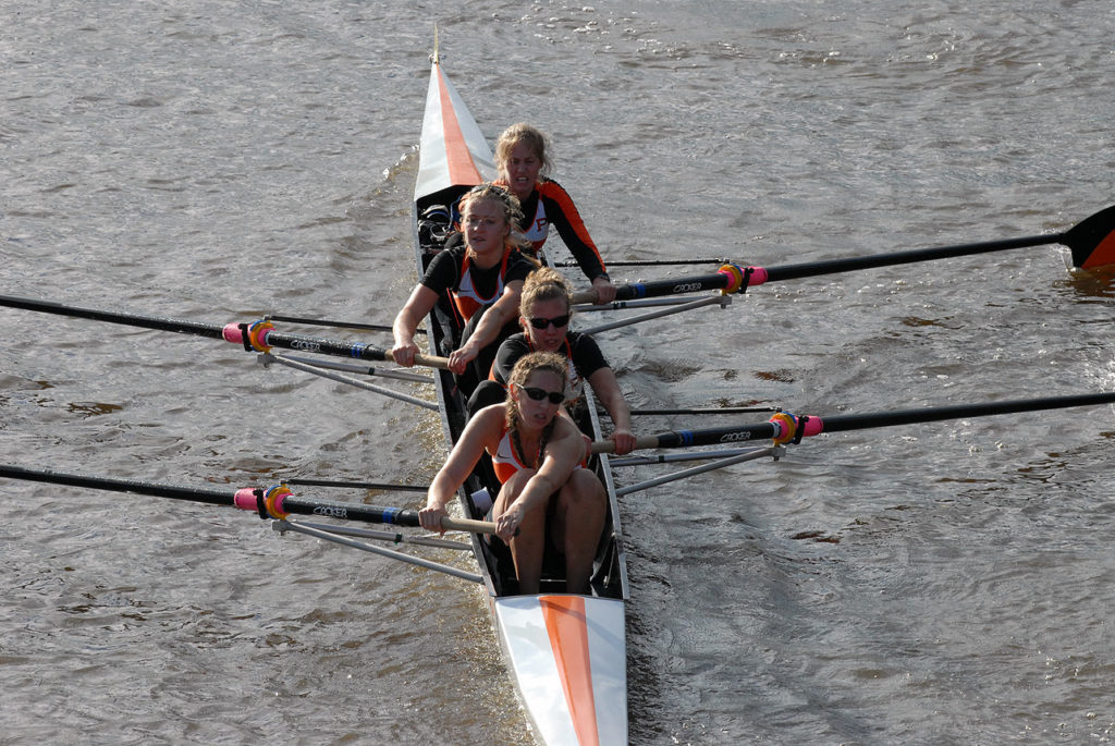 A group of people rowing a boat in the water