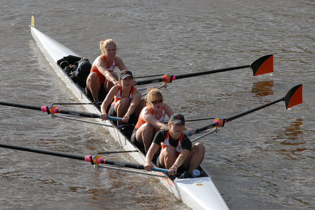 A group of people rowing a boat in the water