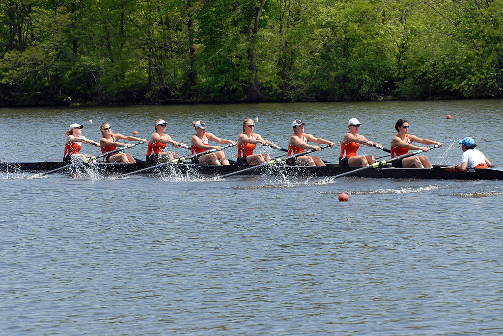 A group of people rowing a boat in a body of water