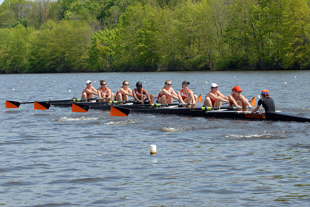 A group of people rowing a boat in a body of water