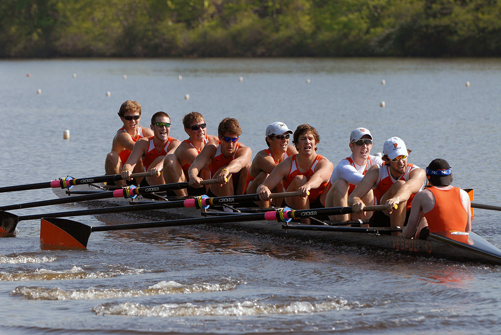 A group of people rowing a boat in a body of water