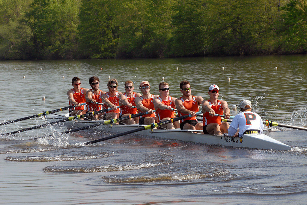 A group of people rowing a boat in the water