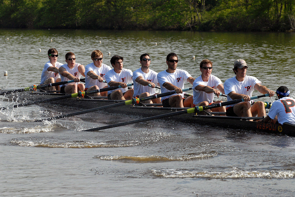 A group of people rowing a boat in a body of water