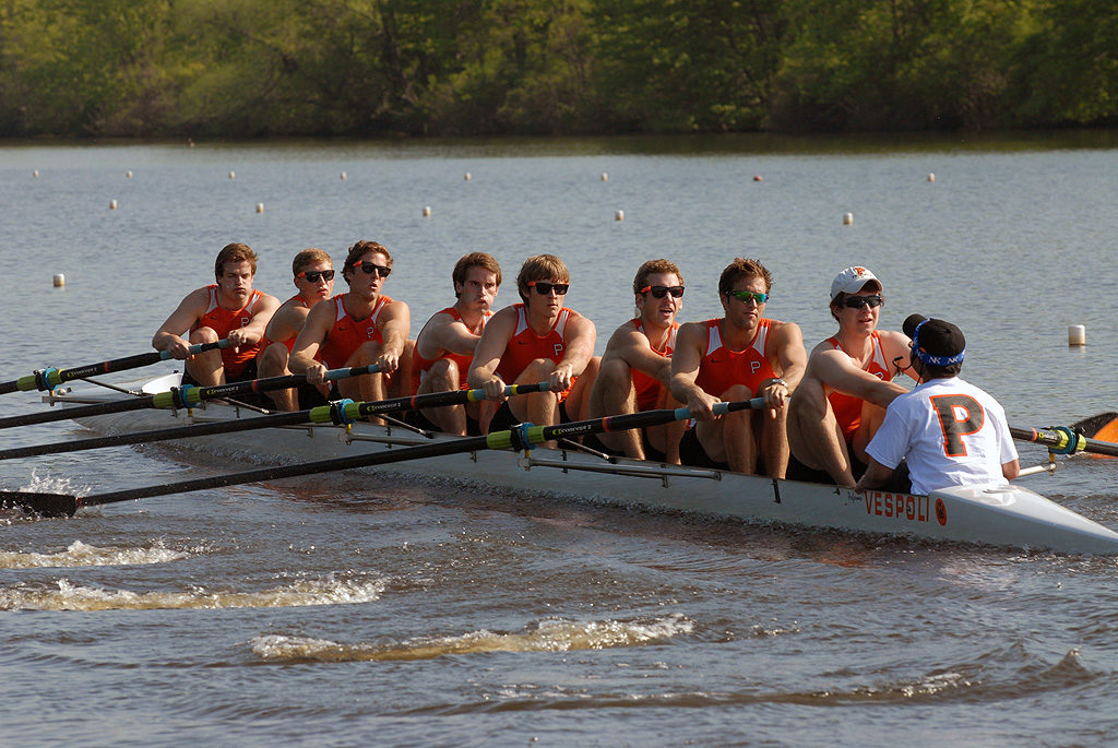 A group of people rowing a boat in a body of water