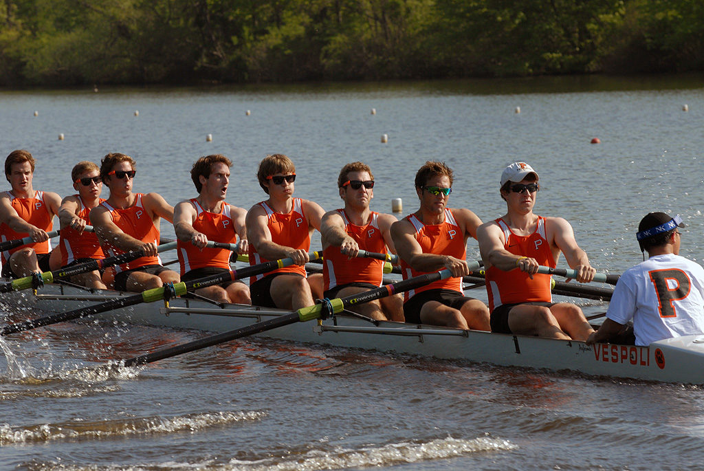 A group of people rowing a boat in a body of water