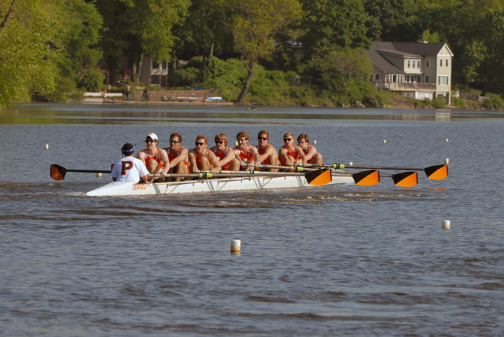 A group of people rowing a boat in a body of water