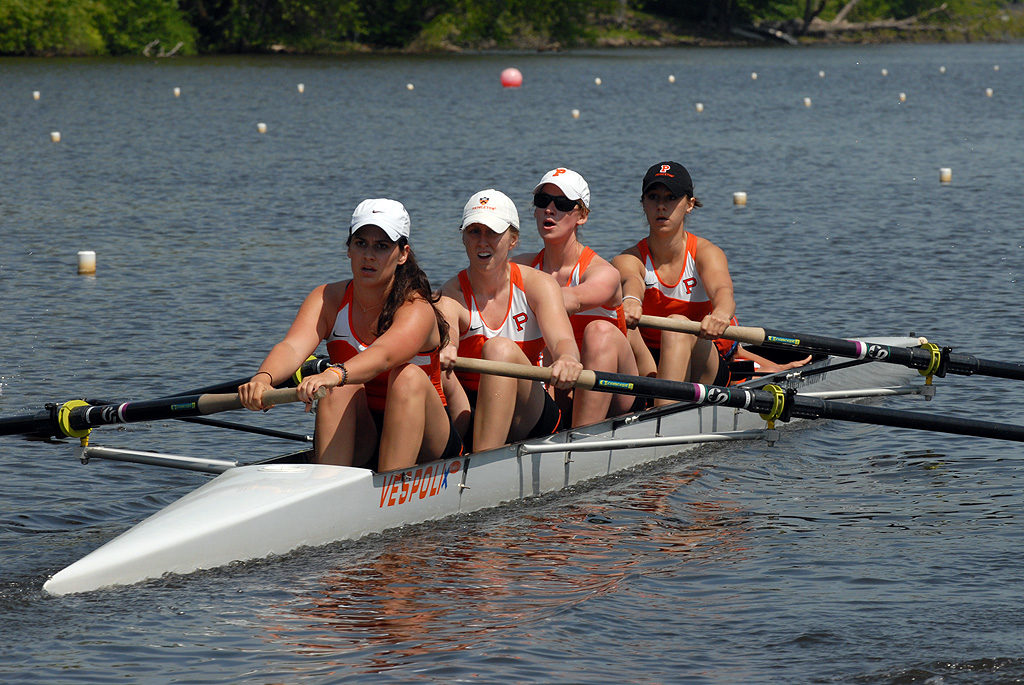 A group of people rowing a boat in a body of water