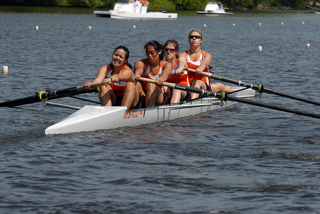 A group of people rowing a boat in a body of water