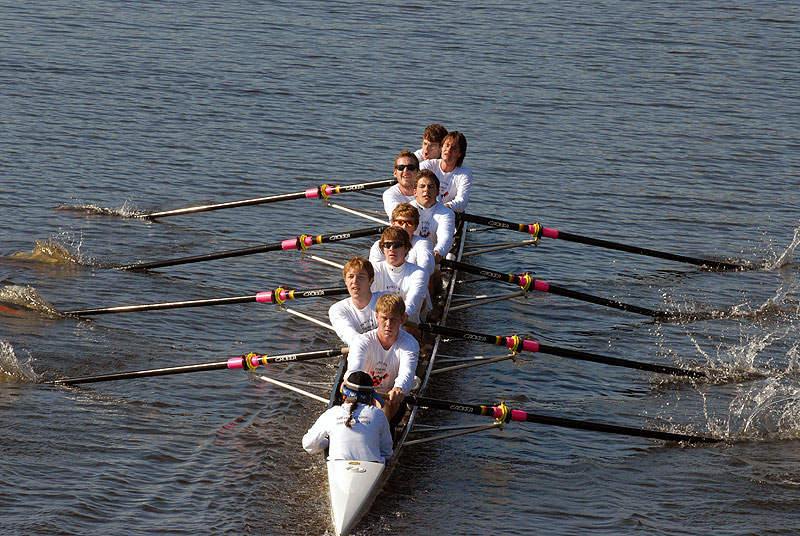 A group of people rowing a boat in the water