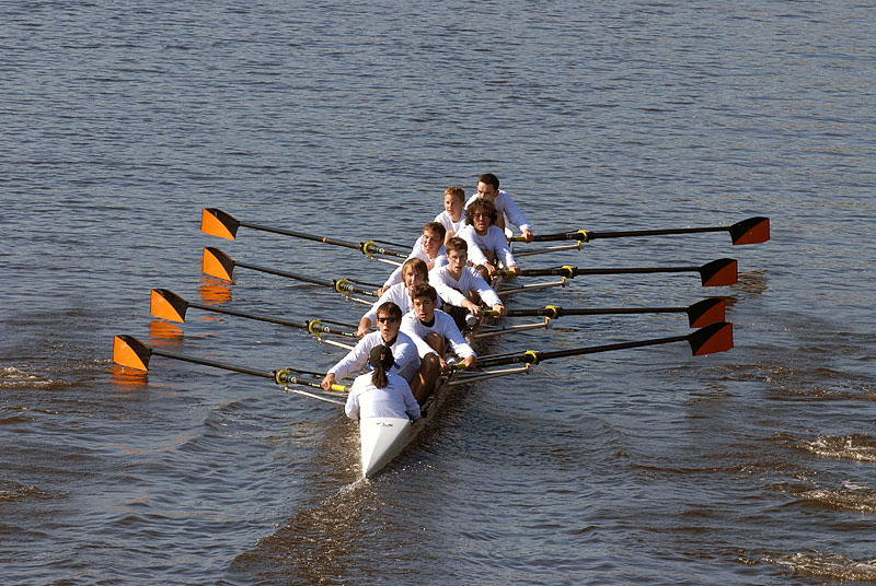 A group of people rowing a boat in the water