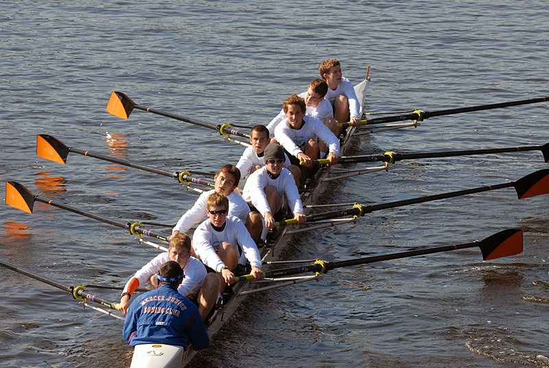 A group of people rowing a boat in a body of water