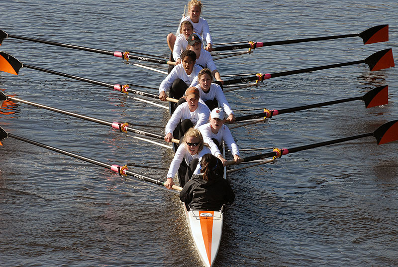 A group of people rowing a boat in the water