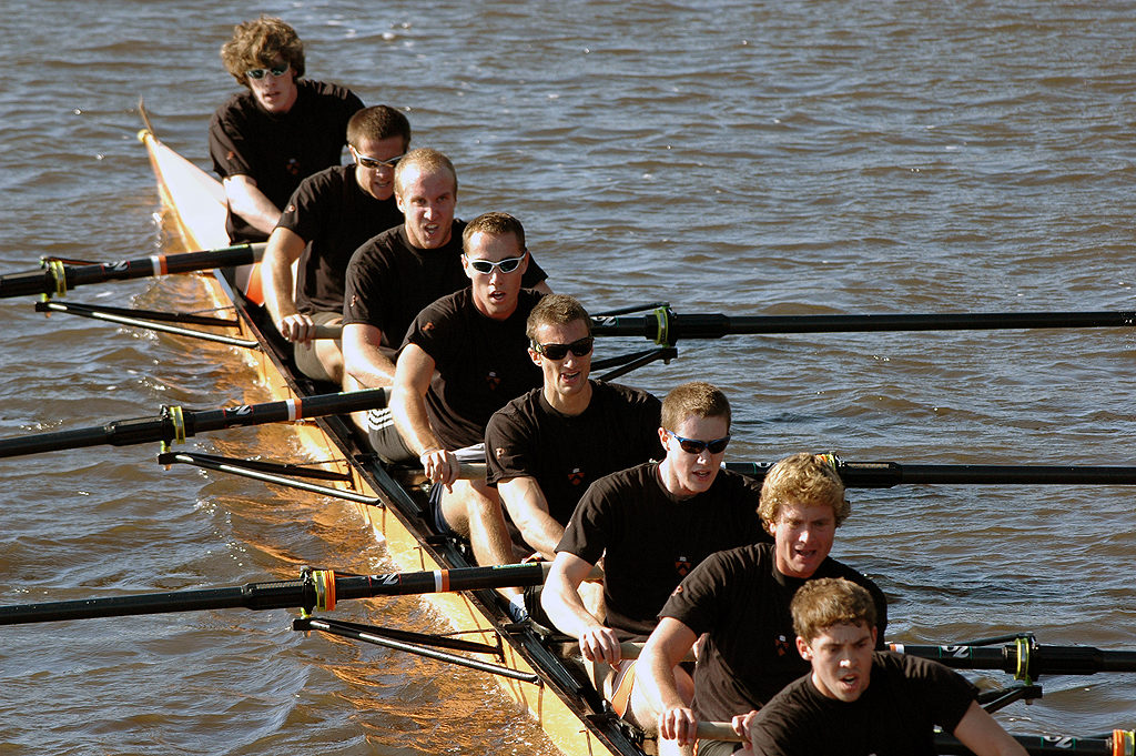 A group of people rowing a boat in a body of water